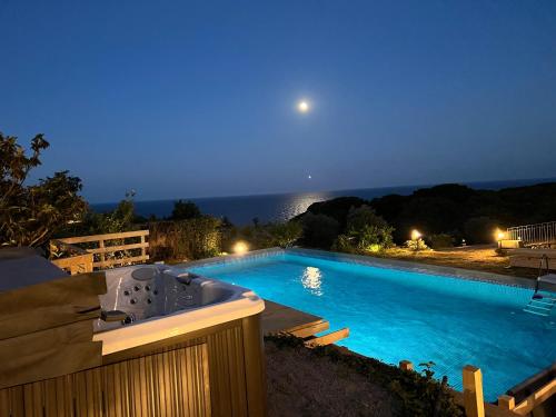 een zwembad in de nacht met een bad bij Villa Petra Sappa - RELAX & WELLNESS in Acireale