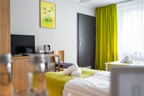 a hotel room with two beds and a television at Słoneczne Wzgórze in Tarnów