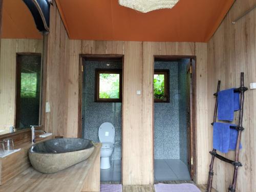 a bathroom with a tub and a toilet and a sink at Sang Giri - Mountain Glamping Camp in Jatiluwih