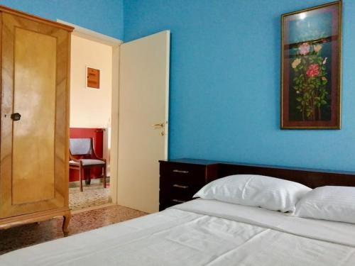 1 dormitorio con cama y pared azul en Anogeio - Traditional house in Tikhion, en Tíkhion