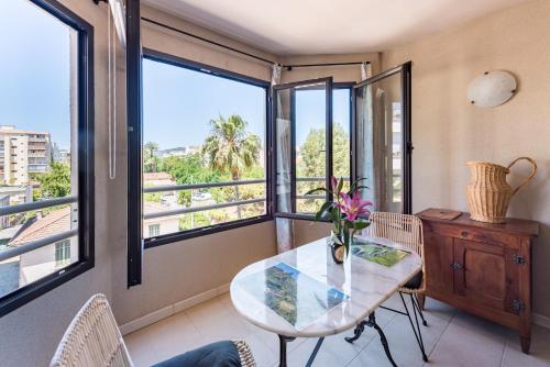 d'une salle à manger avec une table et quelques fenêtres. dans l'établissement Beau Studio Véranda à deux pas de la mer - parking inclus, à Juan-les-Pins
