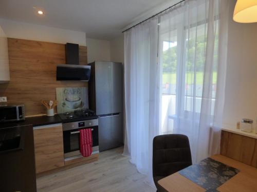 a kitchen with a stove and a refrigerator and a window at Apartmán Dolinky in Vyhne