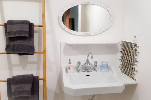 La salle de bains est pourvue d'un lavabo blanc et d'un miroir. dans l'établissement YOG Studios Hossegor, à Soorts-Hossegor
