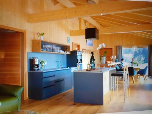 a kitchen with blue cabinets and a table with chairs at Chalet Muehlwiese in Lindberg