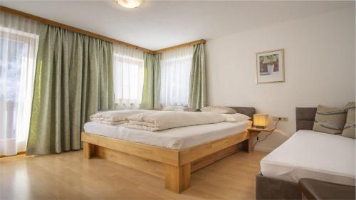 um quarto com uma cama grande em frente a uma janela em Haus Ferchl em Neustift im Stubaital