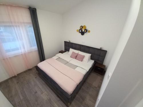 a small bedroom with a bed with pink pillows at Apartments LAURA in Fažana