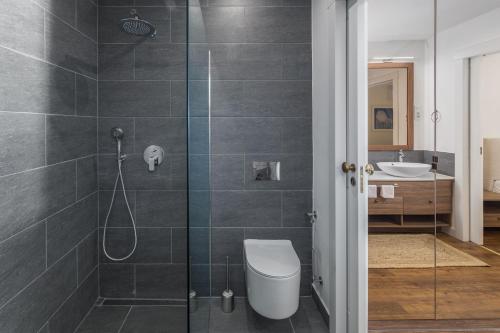 a bathroom with a shower with a toilet and a sink at Luxury Glamping Beach Villas Porto Bus in Bale