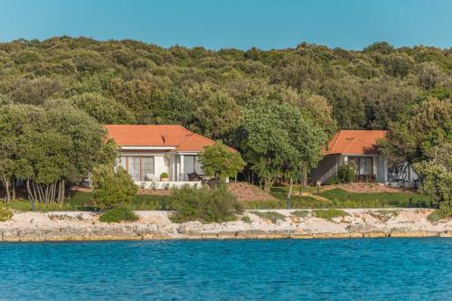 a house on the shore of a body of water at Luxury Glamping Beach Villas Porto Bus in Bale