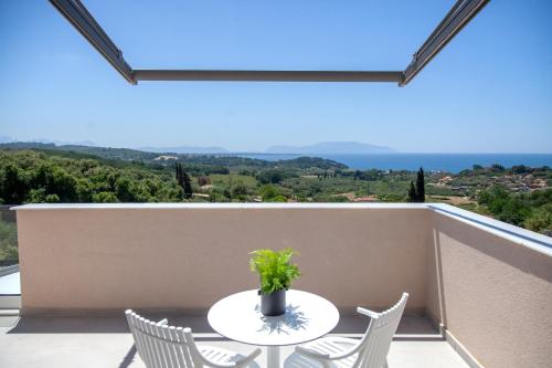 a table and chairs on a balcony with a view at LUMIERE VILLAS in Kanali