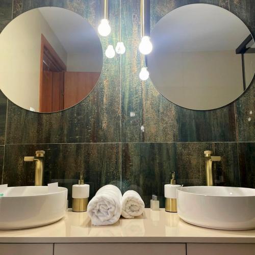 a bathroom with two sinks and a large mirror at Hotel SunGarden Salin in Turda