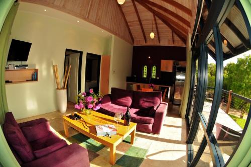 a living room with purple couches and a table at Waterfall Cottages in Margaret River Town