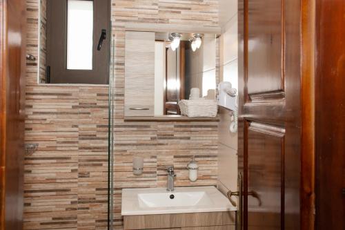 a bathroom with a sink and a mirror at Argo Rooms-Papadakis in Kissamos