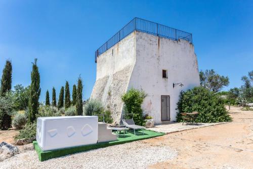 un edificio con una valla encima en Antica Torre vista mare con jacuzzi - Apulia Home, en Capilungo