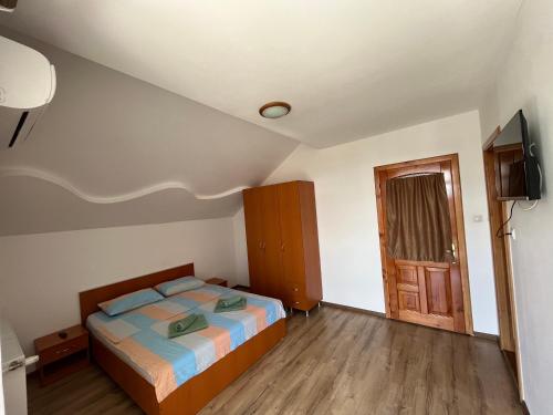 a small bedroom with a bed and a television at Vila Nei in Lugoj