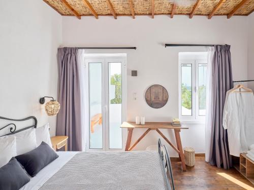 a bedroom with a bed and a table at Psathi Beach House in Kimolos