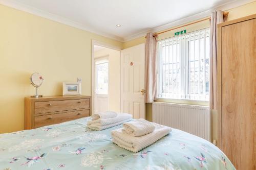 una camera da letto con un letto con asciugamani sopra di 19 Cormorant Drive The Annexe a St Austell