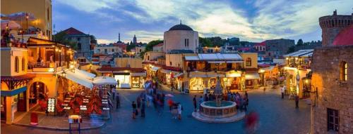 a group of people walking around a city street at OSSIANO POOL VILLAS, Heating Pool, 2 min drive to Haraki Beach & 10 to Lindos in Haraki
