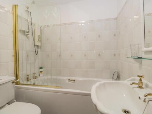 a bathroom with a tub and a sink and a toilet at Swaledale Watch Garden Annexe in Wigton