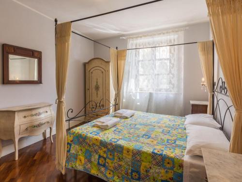 a bedroom with a canopy bed and a dresser at Cheerful holiday home in Serravalle di Chienti with garden in Serravalle di Chienti