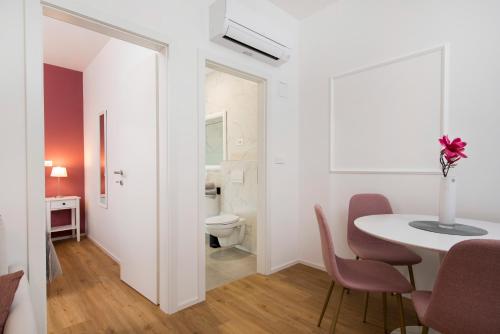 a white room with a table and a toilet at Cozy apartments in Ljubljana