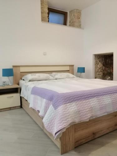a bedroom with a large bed with a purple blanket at Studio apartment Iva in Bale