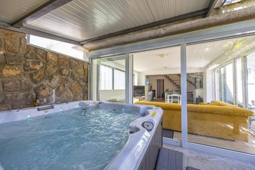 bañera de hidromasaje en una habitación con pared de piedra en Villa Barbara, en Klenovica