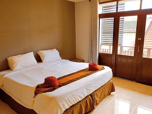 1 dormitorio con 1 cama grande y toallas rojas. en Laemdin Hotel, en Koh Samui 