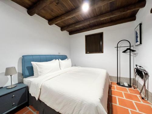 a bedroom with a bed with a blue head board at 金門 日玥居 古厝民宿 Sunmoon19 B&B in Jinning