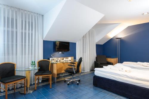 ケンジェジン・コジレにあるHotel Hugo Business & Spaのベッド、テーブル、椅子が備わるホテルルームです。