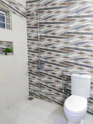 a bathroom with a toilet and a glass shower at Travelodge Guesthouse in Islamabad