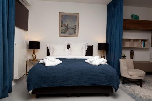 a bedroom with a blue bed with towels on it at Suite Aux Anges in Antwerp