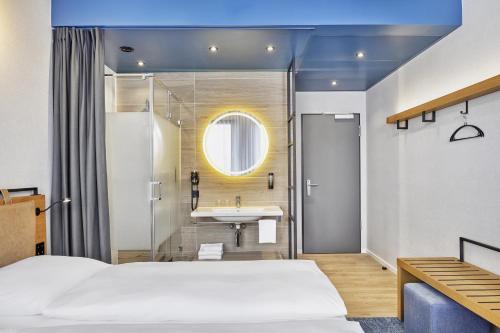 ein Hotelzimmer mit einem Bett und einem Waschbecken in der Unterkunft H2 Hotel Düsseldorf Seestern in Düsseldorf