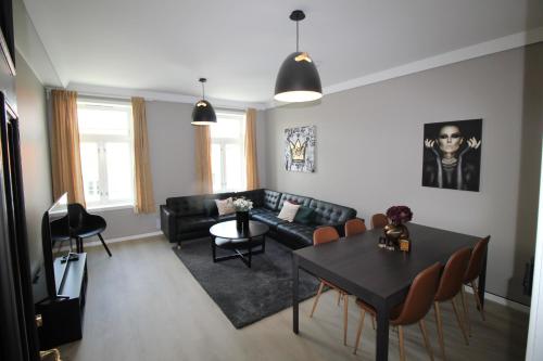 ein Wohnzimmer mit einem schwarzen Sofa und einem Tisch in der Unterkunft KRSferie leiligheter i sentrum in Kristiansand