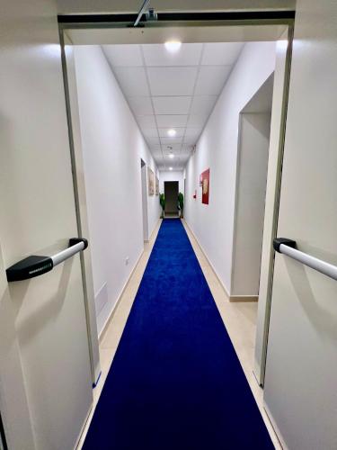 a long corridor with a blue carpet in a hallway at Hotel Terramare in Lido di Jesolo