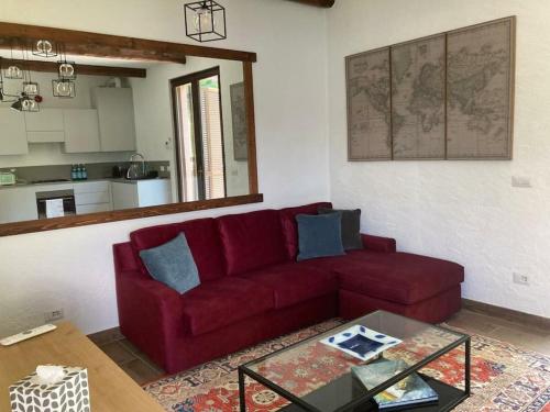 a living room with a red couch and a table at Lussuoso appartamento nella magia del lago d'Orta in Orta San Giulio