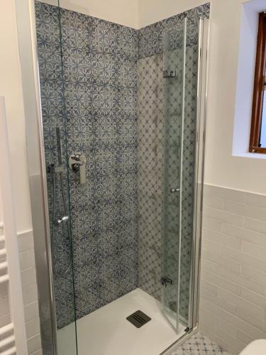 La salle de bains est pourvue d'une douche avec une porte en verre. dans l'établissement TERMOLI, NEL CUORE DEL CENTRO STORICO, à Termoli