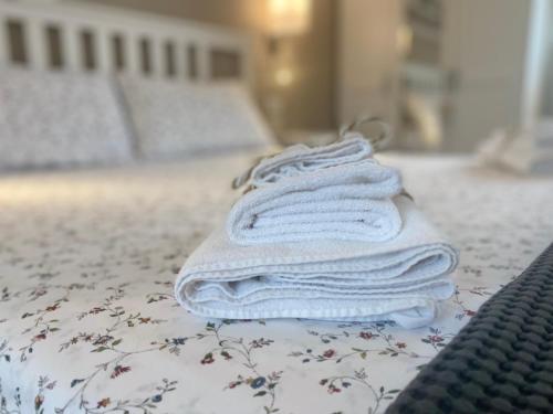 una pila di asciugamani bianchi seduti su un letto di Nature Home a Sandra