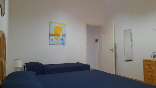 1 dormitorio con 1 cama azul y vestidor en Casa tra gli ulivi., en Castrignano del Capo