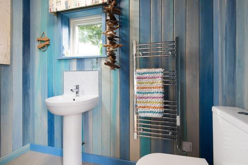 baño con lavabo y aseo y ventana en Berrington Beach Hut, en Berwick-Upon-Tweed