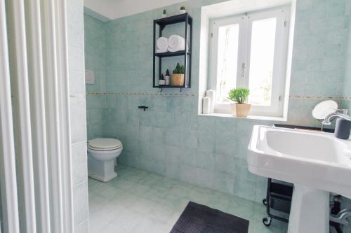 a bathroom with a toilet and a sink and a window at Villa Roberto in Monte San Giusto