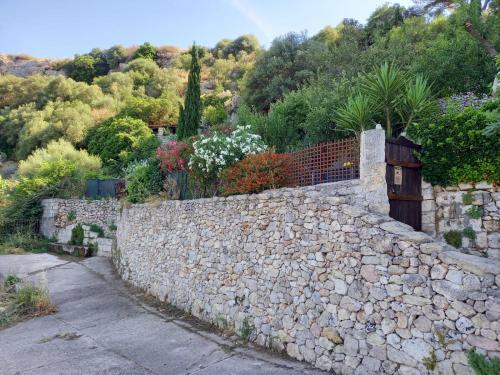 eine steinerne Mauer neben einem Steinzaun in der Unterkunft Vistalago Garden in Monteleone Rocca Doria