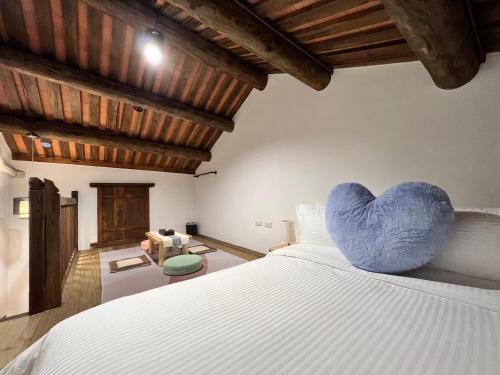 a bedroom with a bed with a blue heart pillow on it at 金門 日玥居 古厝民宿 Sunmoon19 B&B in Jinning