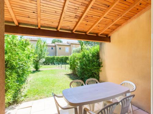 une terrasse avec une table et des chaises sous une pergola en bois dans l'établissement Comfortable holiday home with swimming pool, à Arles
