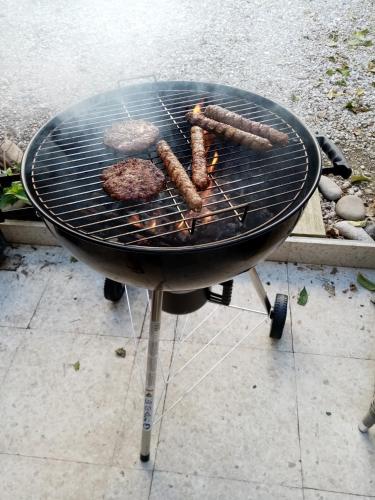 a grill with sausage and hamburgers on it at The Summer Haven in Polis Chrysochous