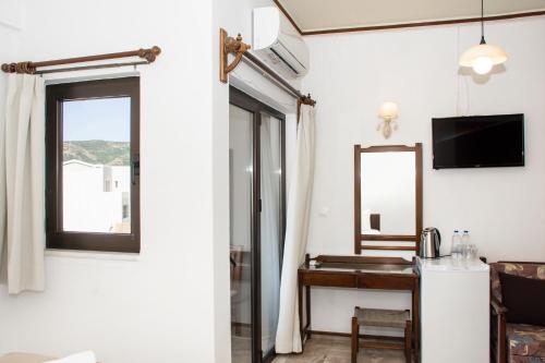 a room with a desk and a mirror and a mirror at Argo Rooms-Papadakis in Kissamos