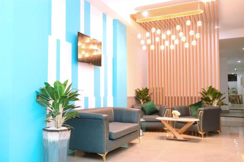 a lobby with couches and plants and a chandelier at HÀO PHÁT HOTEL NHA TRANG in Nha Trang