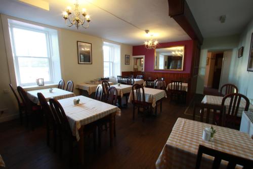 Inn at Ardgour في أونيك: مطعم بطاولات وكراسي وثريا