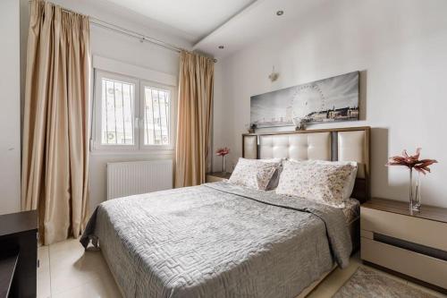 ein Schlafzimmer mit einem großen Bett und einem TV in der Unterkunft Lassani cozy and quiet, 2 bedroom apartm with spacious balcony in Thessaloniki