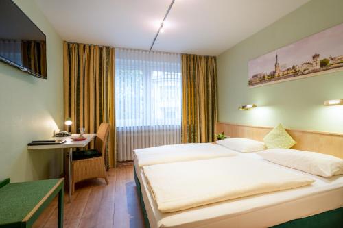 Hotel Arosa Düsseldorf Oberkassel في دوسلدورف: غرفة في الفندق مع سرير ومكتب