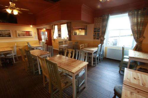 a restaurant with wooden tables and chairs and a window at Inn at Ardgour in Onich